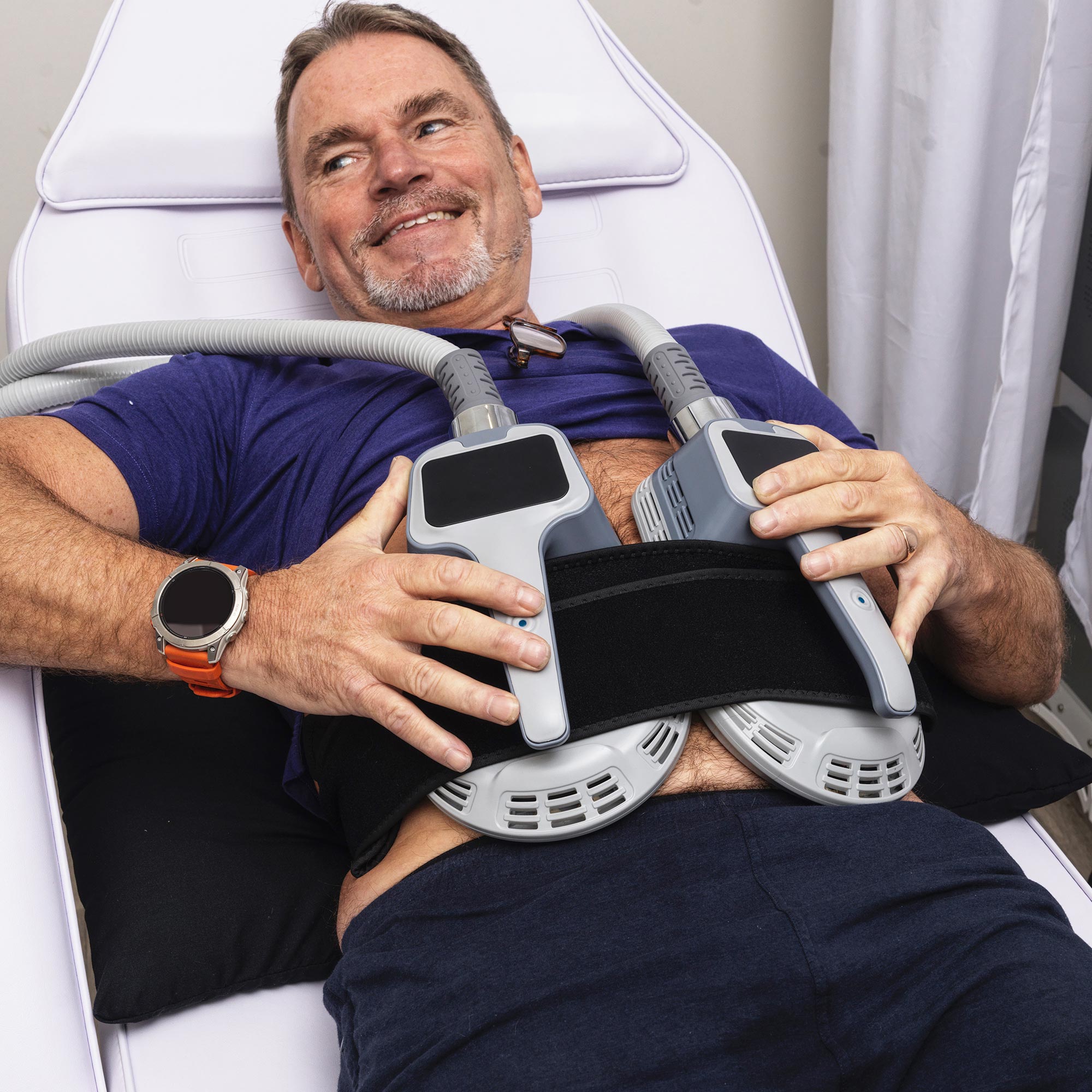 Man using a Musculpting machine on his abs