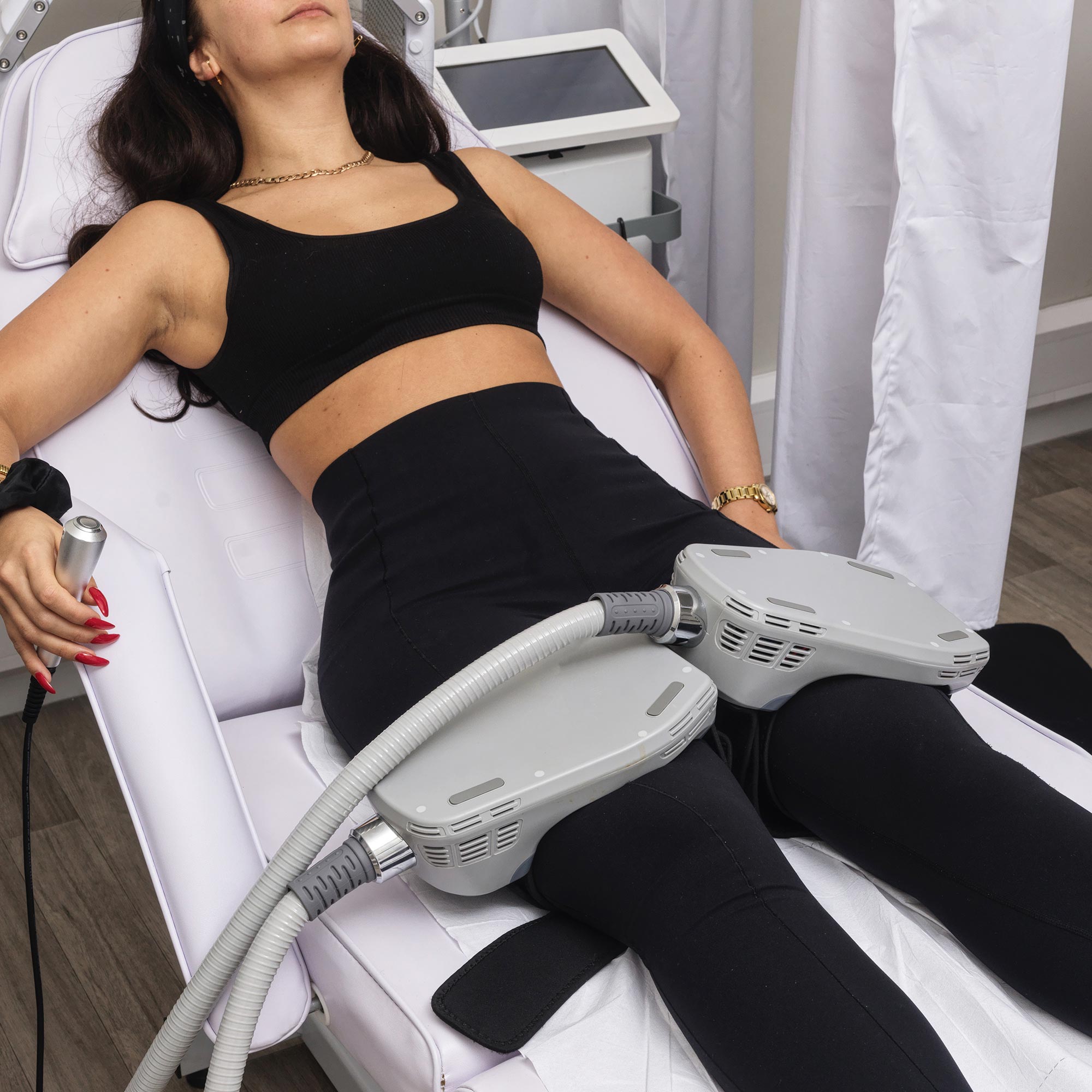 woman using a Musculpting machine on her legs